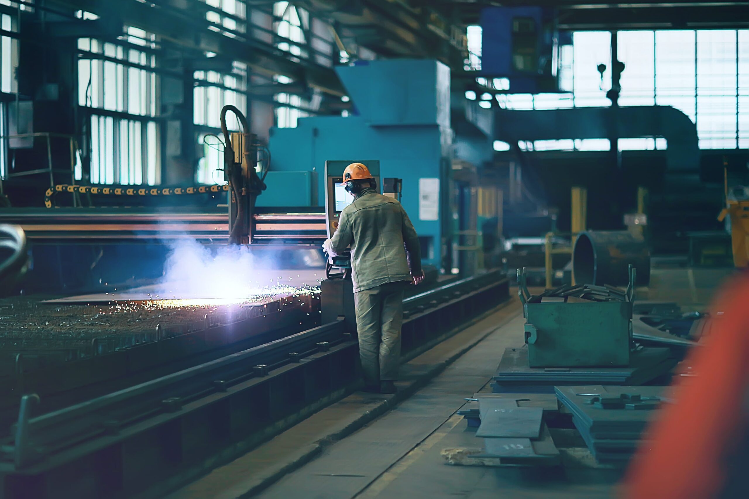 Worker in a factory with high-temperature conveyor belts.
