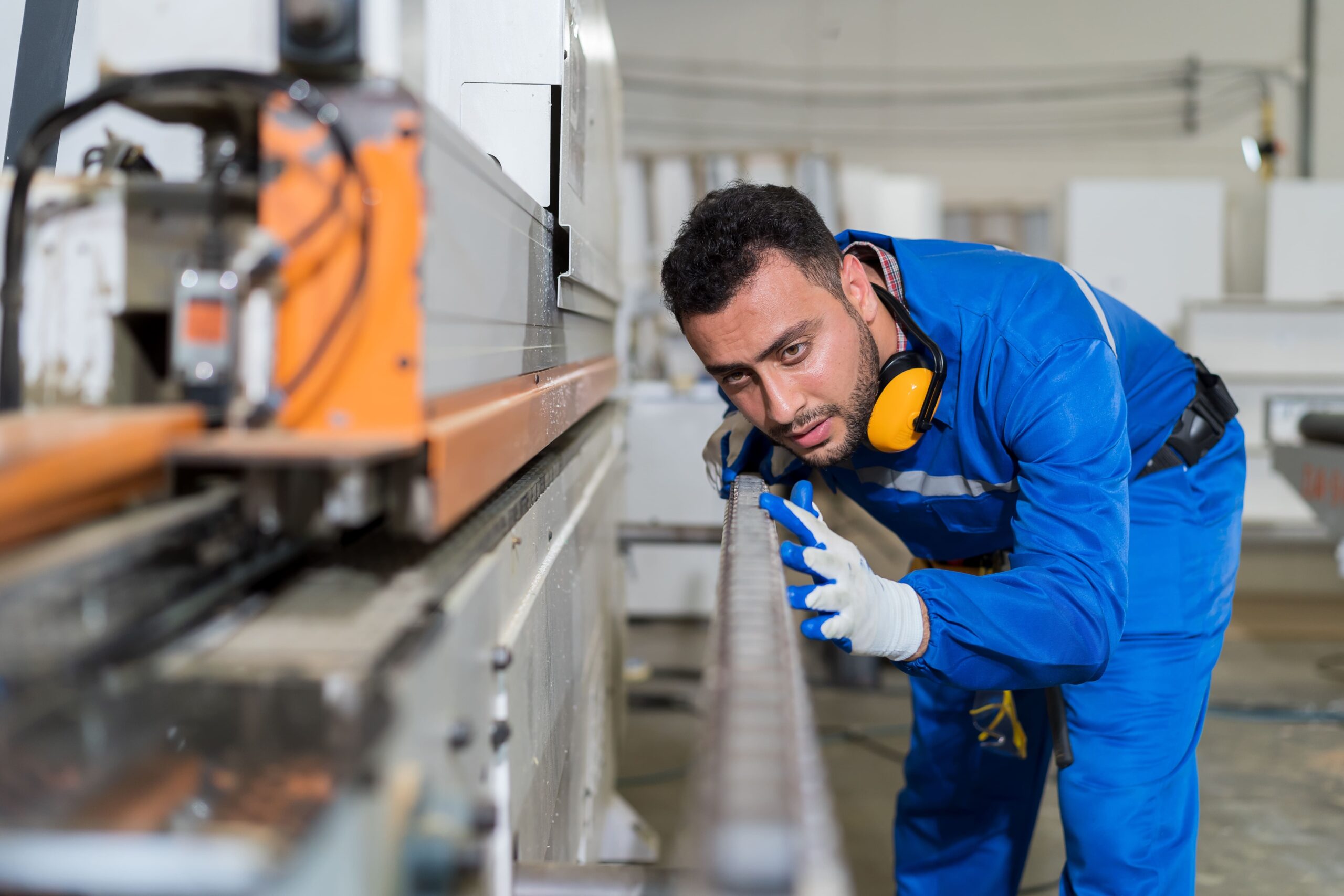 Male engineer checking a conveyor belt.