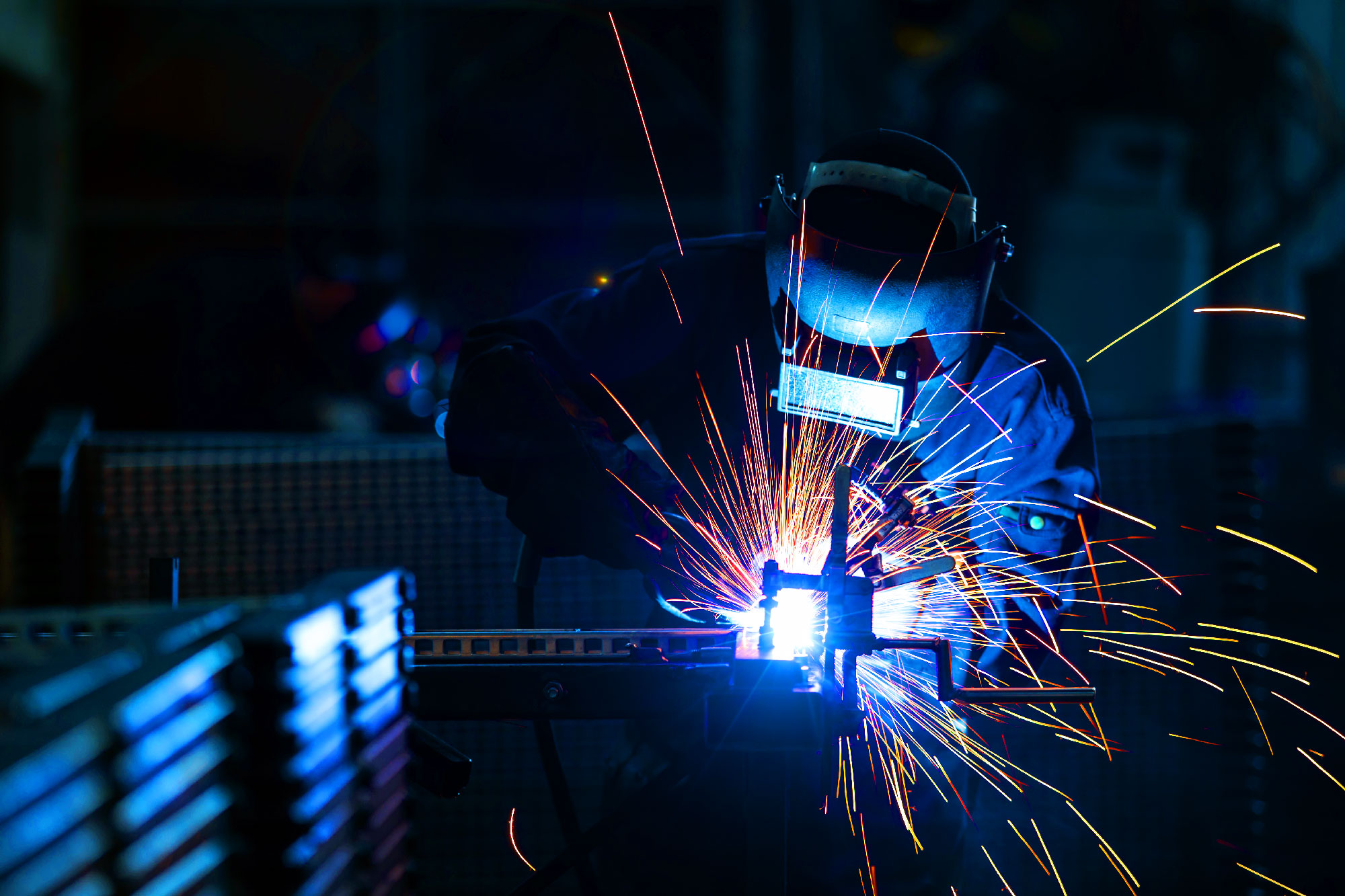 Man in welding gear welding a product.